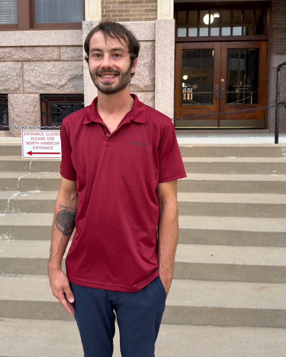 Brandon Nichols of Vyntechs, smiling in a red polo shirt on the front steps of the Johnson County Courthouse in downtown Cleburne, Texas
